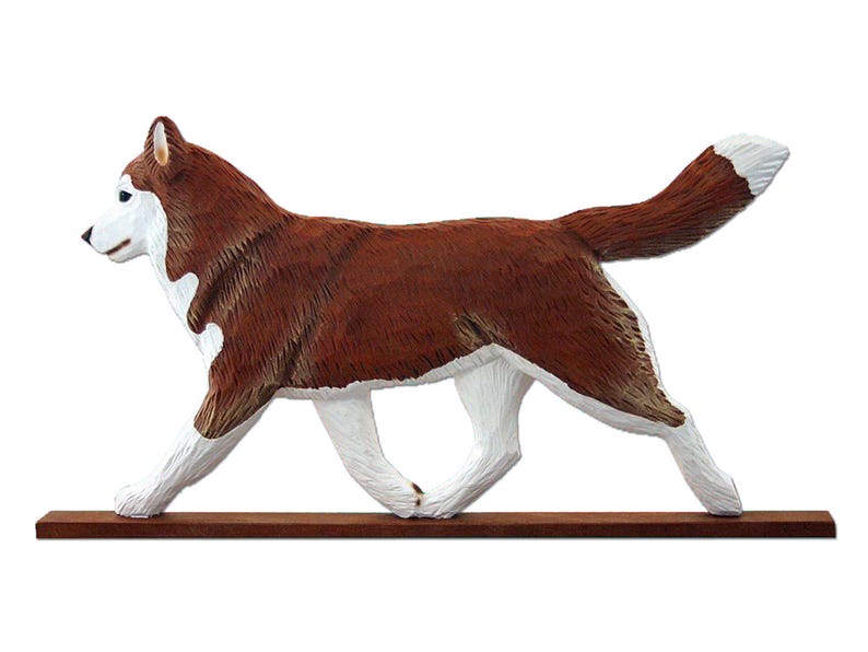 Pu&ograve; includere: Una statuetta di legno di un cane Husky siberiano marrone e bianco che cammina su una base di legno. Il cane &egrave; dipinto con dettagli realistici, tra cui il suo pelo e i suoi occhi.