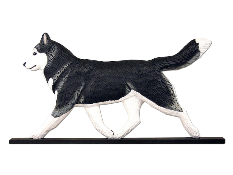 Pu&ograve; includere: Una statuetta di legno di un cane Husky siberiano che corre, dipinta in bianco e nero. La statuetta &egrave; dipinta a mano e ha un aspetto realistico.