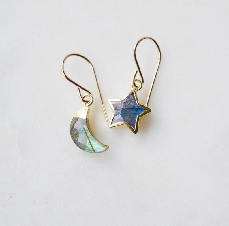 Natural labradorite moon and star stone earrings in gold. One earring is a star the other a crescent.