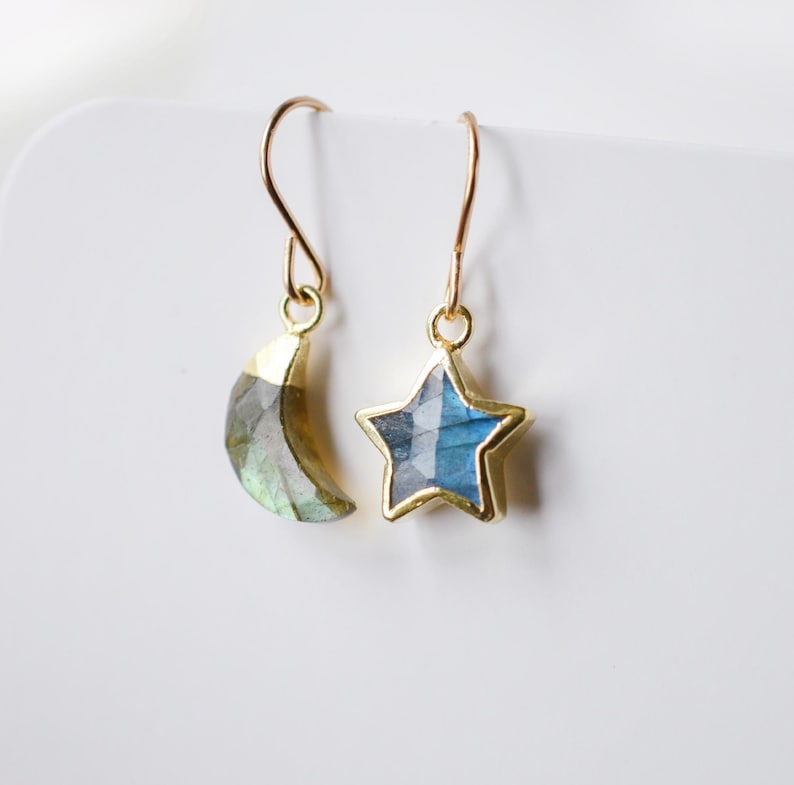 Labradorite moon and star earrings in gold or silver. Shown in gold. One earring is a crescent moon, the other a star.