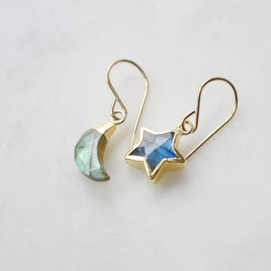 Labradorite moon and star earrings in gold or silver. Shown in gold. One earring is a crescent moon, the other a star.