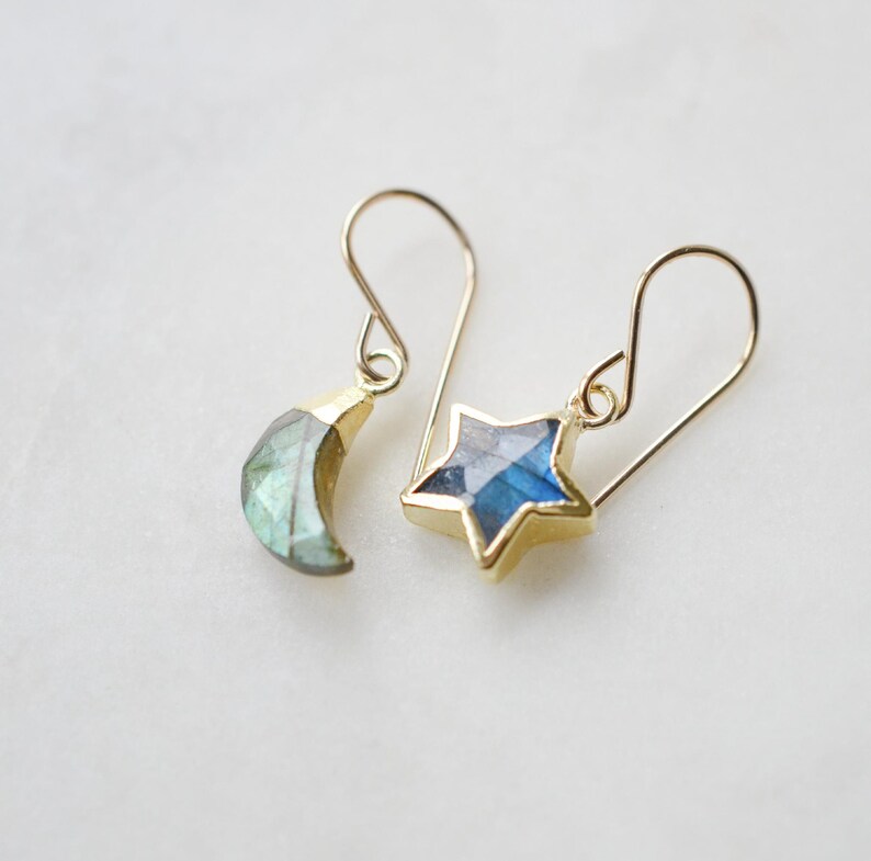 Labradorite moon and star earrings in gold or silver. Shown in gold. One earring is a crescent moon, the other a star.