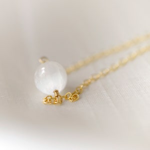Pode incluir: Um delicado colar de corrente de ouro com um &uacute;nico pingente de cristal de selenite branco.
