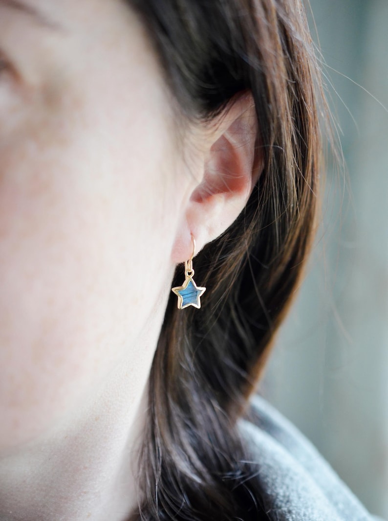 Labradorite moon and star earrings in gold or silver. Shown in gold. One earring is a crescent moon, the other a star.