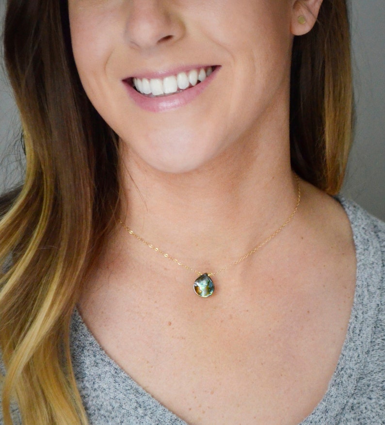 Abalone teardrop set onto a 14k gold filled chain necklace. Modeled image.