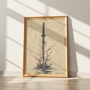 Peut inclure: Œuvre encadrée représentant un katana, avec un manche texturé et une lame noire. Le sabre est placé sur un fond beige craquelé, avec des branches fleuries rouges à sa base. Le cadre en bois ajoute une touche naturelle.