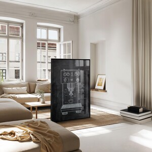 May include: A framed black and white blueprint of an espresso machine. The artwork is displayed in a bright, modern living room with neutral-toned furniture and decor. The room features large windows and a neutral color palette.