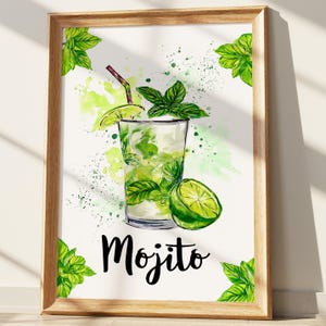 May include: Watercolor print of a Mojito cocktail in a glass, garnished with lime and mint. The artwork features a wooden frame and the word "Mojito" in black script. Green and white watercolor splashes and green leaves surround the drink.