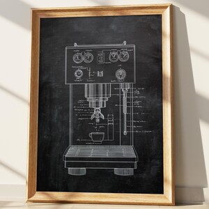May include: A framed print featuring a detailed blueprint of an espresso machine. The design is rendered in white lines against a dark background, showcasing the machine's components, gauges, and a cup. The frame is made of wood.