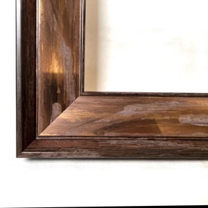 May include: A rectangular picture frame featuring a wide, flat profile with a distressed finish. The surface displays a blend of dark brown and metallic copper tones, with visible brushstroke textures and lighter, worn patches along the edges.