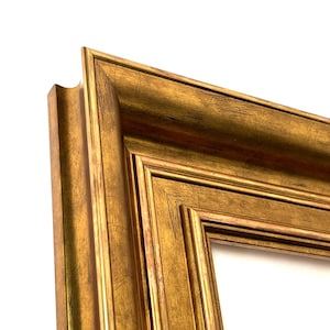 May include: A rectangular picture frame featuring a metallic gold finish with a distressed, textured surface. The frame has a multi-tiered, stepped profile with deep grooves and raised edges, showcasing a classic, ornate design with visible aging.