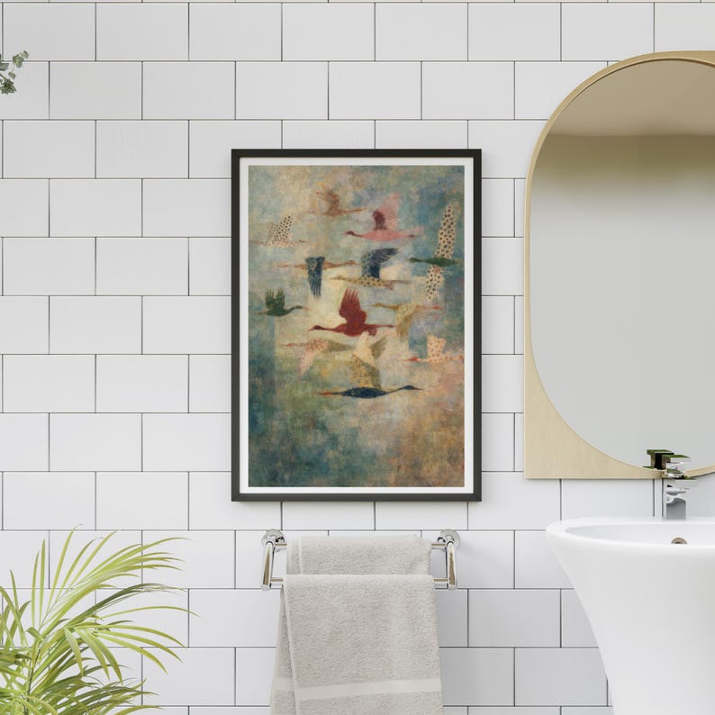 May include: A framed art print featuring a flock of birds in flight. The birds are depicted in various colors, including red, blue, and green, against a textured, muted background. The artwork is displayed in a bathroom setting.