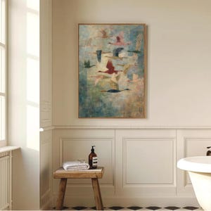 May include: A framed artwork featuring a flock of birds in flight. The birds are depicted in various colors, including red, green, and blue, against a muted, textured background. The artwork is displayed in a bathroom setting.