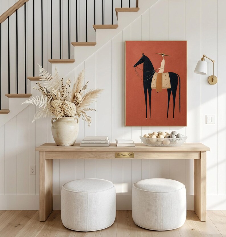 Folk art print of a figure in a wide-brim hat riding a tall dark horse with a tan saddle blanket on a warm terracotta background, vertical mid century equestrian wall art.
