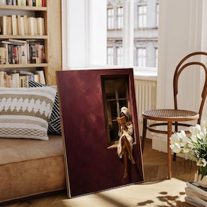 Painting of a Black woman in a white towel reading a golden book on a sunlit windowsill against a deep burgundy wall, moody figurative wall art print.