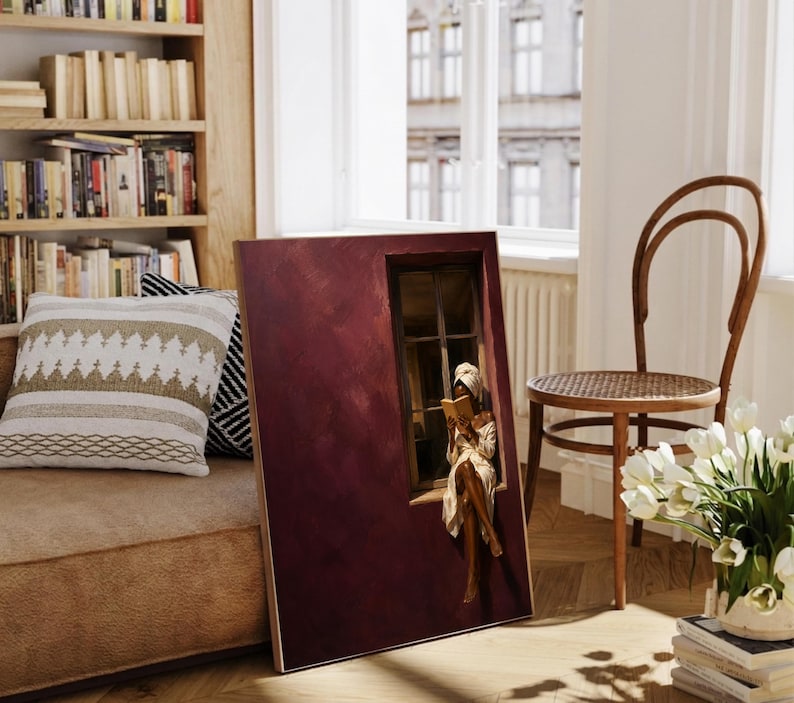 Painting of a Black woman in a white towel reading a golden book on a sunlit windowsill against a deep burgundy wall, moody figurative wall art print.