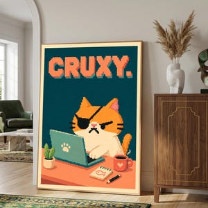 Könnte beinhalten: Ein gerahmtes Pixel-Art-Poster mit einer orange-weißen Katze, die eine Augenklappe trägt und an einem türkisfarbenen Laptop arbeitet. Der Text CRUXY. steht in orangefarbenen Pixelbuchstaben darüber, ergänzt durch eine kleine Pflanze und eine Tasse.
