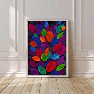 May include: A framed art print featuring a vibrant arrangement of colorful leaves. The leaves are in shades of red, blue, green, orange, and purple, set against a dark background. The artwork is displayed in a white frame.