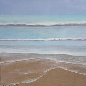 May include: An original painting of a beach scene. The artwork depicts the ocean with waves and a sandy shore. The colour palette includes shades of blue, turquoise, and brown, creating a serene and calming atmosphere. The painting is signed in the lower left corner.