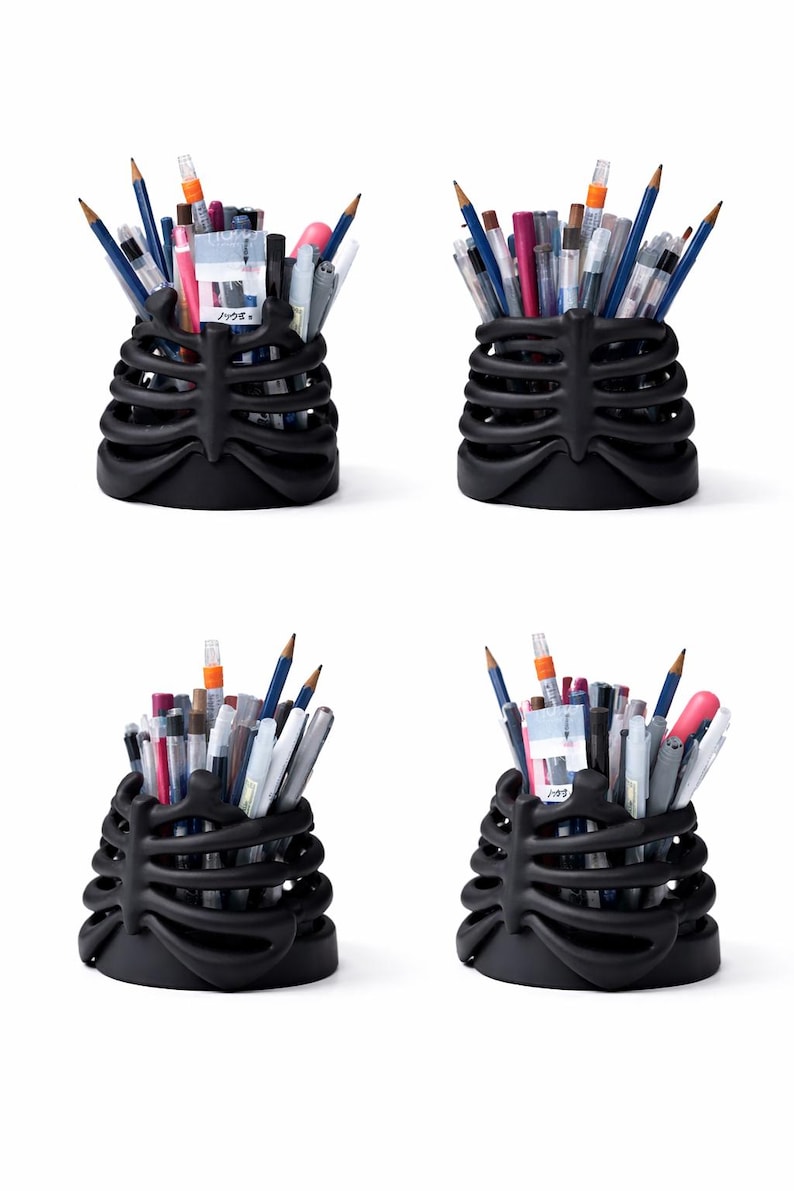 May include: Four black desk organizers shaped like a human rib cage, each filled with various pens, pencils, and markers. The matte black containers feature curved, horizontal rib-like structures that hold writing instruments upright.