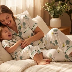 Puede incluir: Taza de cer&aacute;mica blanca con asa negra y la frase "But First, Coffee" en negro. El fondo borroso sugiere un ambiente acogedor.