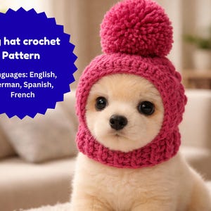 Könnte beinhalten: Ein kleiner, hellfarbener Hund trägt einen leuchtend rosa gehäkelten Hut mit einem Bommel. Der Hut bedeckt den Kopf und die Ohren des Hundes, mit einer Öffnung für das Gesicht. Text auf einem blauen Stern: "Dog hat crochet Pattern".