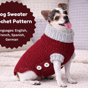 May include: A small dog wearing a red and grey crochet dog sweater with two white buttons. The sweater has a grey turtleneck and cuffs. Text on the image reads "Dog Sweater Crochet Pattern" and lists languages.