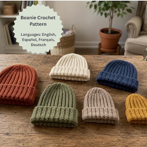 Puede incluir: Seis gorros de ganchillo en varios tamaños y colores, incluyendo óxido, crema, azul marino, verde oliva, beige y amarillo mostaza. Un letrero verde claro en forma de estrella muestra el texto: Beanie Crochet Pattern. Languages: English, Español, Français, Deutsch.