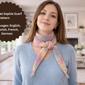 Op de afbeelding: Een vrouw draagt een kleurrijke, gehaakte sjaal die om de nek is geknoopt. De sjaal heeft pastelkleuren, waaronder roze, geel en blauw. De afbeelding bevat de tekst "Crochet Sophie Scarf Pattern" en de beschikbare talen.