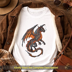 May include: White t-shirt featuring a detailed illustration of a dragon with orange and gray wings and body. The dragon is exhaling smoke. The text at the bottom of the shirt reads, "Kindly Read the Complete Description!"