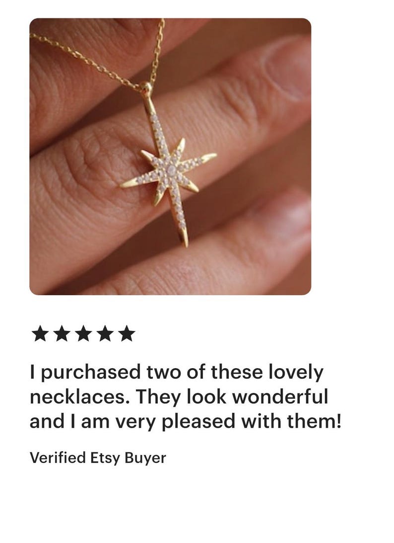 May include: A gold-colored necklace with a starburst pendant, adorned with small, clear gemstones. The necklace is displayed against a neutral background, highlighting the jewelry's design and sparkle.