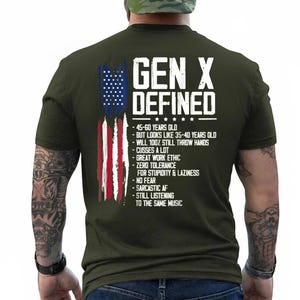 May include: An olive green t-shirt featuring a distressed American flag graphic and white text that reads: GEN X DEFINED, 45-60 years old, but looks like 35-40 years old, will 100% still throw hands, cusses a lot, great work ethic, zero tolerance for stupidity & laziness, no fear, sarcastic AF, still listening to the same music.