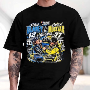 May include: A black short-sleeve t-shirt featuring a graphic print of NASCAR drivers Ryan Blaney and Carson Hocevar. The design includes the text "Ryan Blaney," "Carson Hocevar," "The Two-Piece," and "Some Races Hit Different" with race cars.