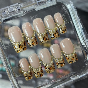 Uñas postizas largas de tacón de aguja con estampado de leopardo y punta francesa, con diamantes de imitación, color dorado y estampado de guepardo. Uñas postizas hechas a mano.