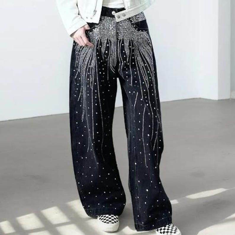 Unisex Rhinestone Pants | Wide Leg Studded Jeans | Glitter Streetwear Fashion Bottoms
.
Wide-leg black pants decorated with cascading rhinestones and glitter stud details shown in a studio setting.