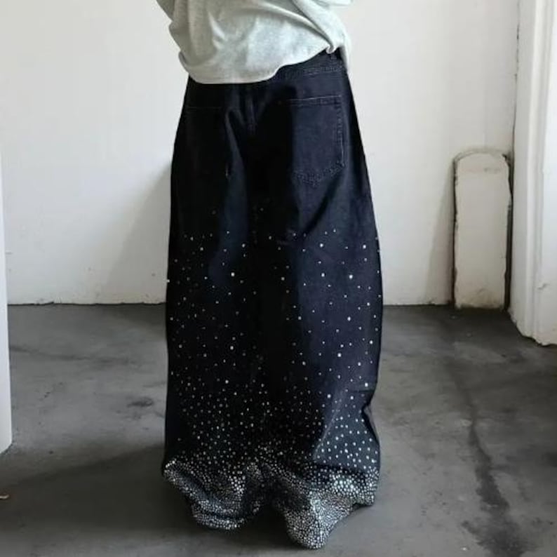 Unisex Rhinestone Pants | Wide Leg Studded Jeans | Glitter Streetwear Fashion Bottoms
.
Wide-leg black pants decorated with cascading rhinestones and glitter stud details shown in a studio setting.