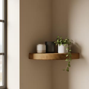 May include: A wooden corner shelf displays three ceramic pots: a white and beige jar, a black pot, and a white pot with a trailing green plant. The shelf is mounted on a beige wall near a window.