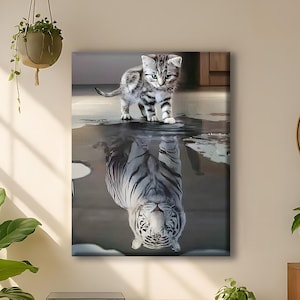 May include: A canvas print depicts a kitten standing above its reflection, which appears as a white tiger. The kitten has gray and black stripes, and the tiger reflection has black stripes. The artwork is displayed in a room with a yellow cabinet and plants.