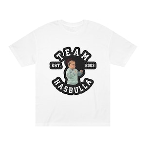 Könnte beinhalten: Weißes T-Shirt mit einer Grafik einer Person und dem Text "TEAM HASBULLA EST. 2003" in Schwarz und Weiß. Das Design ist mittig auf der Vorderseite des T-Shirts platziert.