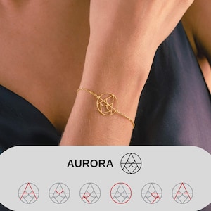 May include: A gold-colored bracelet with a geometric circular pendant. The pendant features an abstract design within a circle. The word "AURORA" is displayed in white text on a gray background. The bracelet is worn on a wrist.