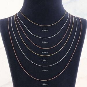 Peut inclure: Pr&eacute;sentation de six colliers cha&icirc;nes d&eacute;licats de diff&eacute;rentes longueurs, de 35,5 cm &agrave; 61 cm, sur un mannequin noir. Les cha&icirc;nes sont en or, argent et or rose, avec la longueur de chaque cha&icirc;ne clairement indiqu&eacute;e.