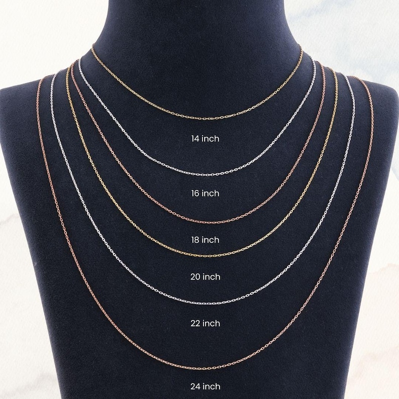 Peut inclure: Pr&eacute;sentation de six colliers cha&icirc;nes d&eacute;licats de diff&eacute;rentes longueurs, de 35,5 cm &agrave; 61 cm, sur un mannequin noir. Les cha&icirc;nes sont en or, argent et or rose, avec la longueur de chaque cha&icirc;ne clairement indiqu&eacute;e.