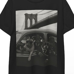 Pode incluir: T-shirt preto com um gráfico a preto e branco de três cães num carro antigo, com a ponte de Brooklyn ao fundo. Os cães usam chapéus e fatos.