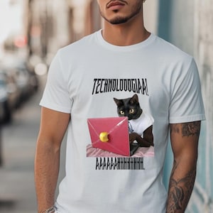 Può includere: T-shirt bianca con la scritta "TECHNOLOOOGIA!" sopra una grafica di un gatto nero che usa un laptop rosso con un logo a forma di mela gialla. Il testo "AAAAAAHHHHHHHHHH." è sotto il gatto.