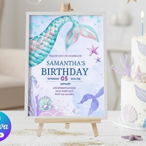 以下が含まれることがあります： 小さな木製イーゼルに飾られた、人魚をテーマにした誕生日の招待状。招待状には人魚の尾のデザインとイベントの詳細が記載された「Samantha's Birthday」の文字が描かれています。背景には、人魚の尾の装飾が施されたお揃いのケーキがあります。