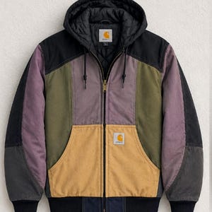 May include: A color-blocked hooded jacket featuring a black quilted hood, a gold-colored front pocket, and panels in shades of olive green, purple, and black. The jacket has a full-length front zipper and a Carhartt brand label on the chest.