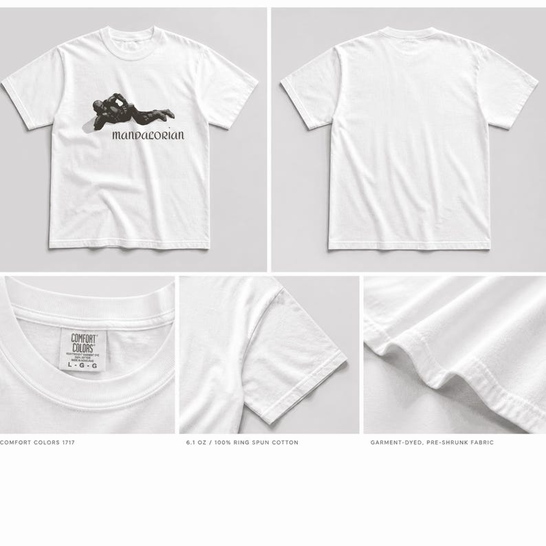 May include: White t-shirt featuring a black graphic of a figure and the word "MANDALORIAN". The shirt is made of 6.1 oz ring spun cotton. The image also shows details of the shirt's collar, sleeve, and hem.