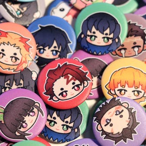 Peut inclure: Une collection de boutons ronds et colorés avec des illustrations de personnages de style anime. Les boutons ont différentes couleurs de fond, notamment le rouge, le bleu, le violet et le jaune. Chaque bouton affiche un personnage différent avec des cheveux et des traits du visage uniques.