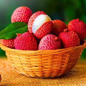 May include: A wicker basket overflowing with lychees. The lychees are a bright red hue with bumpy skin, and one is partially peeled, showing the white flesh. A green leaf rests amongst the fruit, and the basket is on a textured surface.