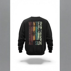 Peut inclure: Sweat-shirt noir avec un design rétro avec les mots "WINTER AT SUN" et des palmiers. Le design comprend des rayures verticales de différentes couleurs. Le texte "LA SEYNE SUR MER" est imprimé verticalement.